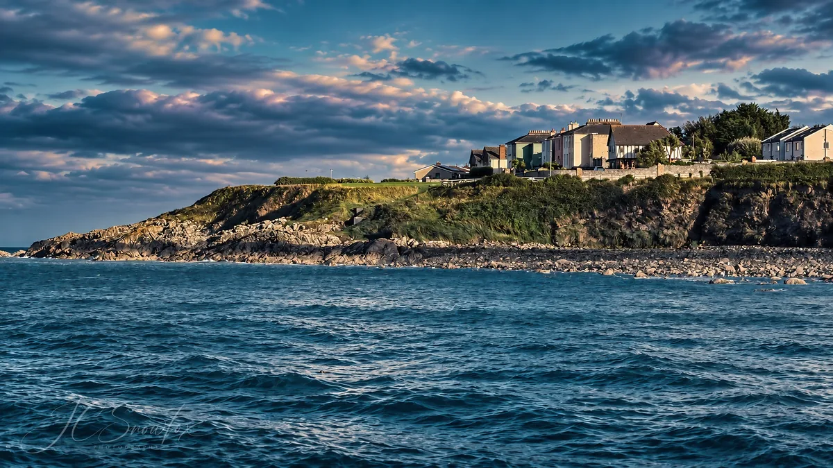 A coastal village under a moody blue sky