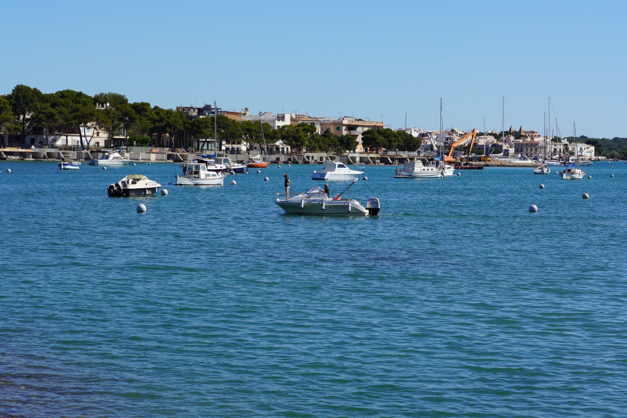 Small boats moored across calm turquoise harbour water